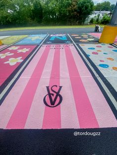 a colorful parking lot with the word v on it and flowers painted on the ground