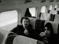 black and white photo of two men sitting on an airplane