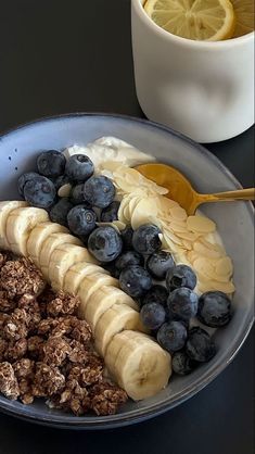 a bowl filled with cereal, bananas and blueberries