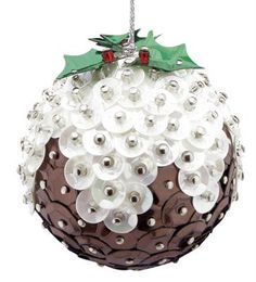 a christmas ornament with buttons and holly leaves on the top, hanging from a wire