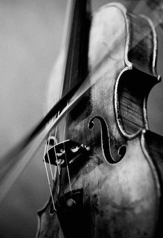 an old violin is hanging on the wall in black and white photo with light coming from behind it