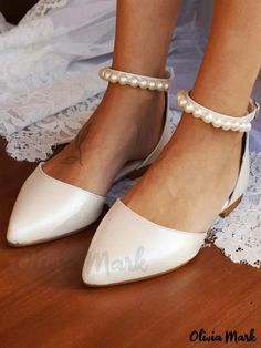 the bride's shoes are white with pearls on them and her name is mark