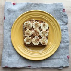 banana slices and cinnamon toast on a yellow plate with a gray napkin next to it