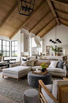 a living room filled with lots of furniture and large windows in the wall above it