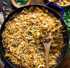 a skillet filled with pasta, meat and parsley