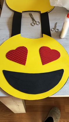 a yellow smiley face with red hearts on it's eyes and two pairs of scissors