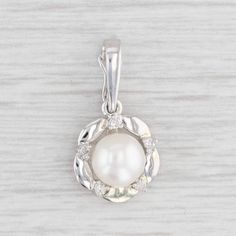 Gemstone Information: - Cultured Pearl - Size - 6.7 mm  Cut - Round Bead Shape Color - White - Natural Diamonds - Total Carats - 0.03ctw Cut - Single Color - F - G Clarity - SI2 - I1 Metal: 14k White Gold Weight: 1.5 Grams  Stamps: 14k Measurements: 20.5 x 11.1 mm (including bail) The bail will accommodate up to a 2.3 mm chain. This bail has a snap closure which allows it to be easily placed on various chains. Each piece is thoroughly examined and refinished as needed by our professional jewelers, graded by our in-house GIA (Gemological Institute of America) Graduate Gemologist, and inspected for quality before being carefully packaged and promptly shipped. [SKU: B25612] phd Round Pearl Pendant Jewelry For Anniversary, Anniversary Round Pearl Pendant Jewelry, Elegant Pearl Birthstone Necklace, Pearl Jewelry With Prong Setting, Fine Jewelry Pearl Necklace With Brilliant Cut Round Pendant, Diamond White Round Cut Pearl Jewelry, Pearl Jewelry With Brilliant Round Cut, Anniversary Pearl Necklace With Diamond Accents, Diamond White Akoya Pearl Round Jewelry