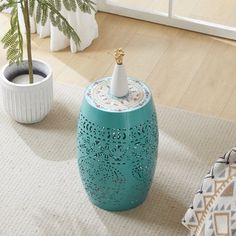 a blue stool sitting on top of a white rug next to a potted plant