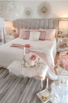 a bedroom decorated in pink, white and gold with candles on the nightstands next to the bed