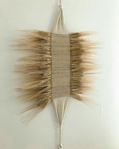 a wall hanging made out of woven material with long hair on it's side