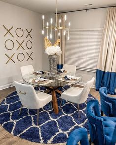 a dining room with blue chairs and a round glass table