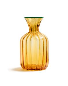 a yellow glass vase sitting on top of a white table