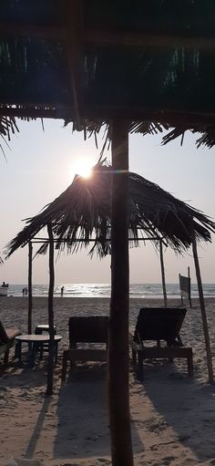 the sun shines brightly through some straw umbrellas