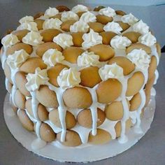 a cake with white frosting and icing on a glass plate sitting on a table