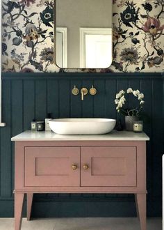 a bathroom with a sink, mirror and floral wallpaper on the walls behind it