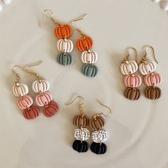 four pairs of earrings on a plate