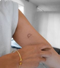 a woman's arm with a small tattoo on the left side of her arm