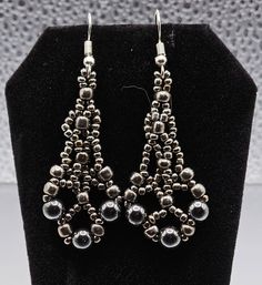 The open design gives a filigree look to these gorgeous Earrings. Wearing these Earrings will dress up any outfit you wear.  They can make you feel like royalty from the past.  The colors in these earrings are a blend of Gray and Dark Gray glass beads.   A color combination that will accent any outfit you chose to wear.  The Beaded Earrings are 1 and 3/4 inches long, Each Earring is 3/4 inch wide.  Including the Earwire they are 2 and 1/2 inches long. Elegant Nickel-free Chandelier Earrings With Round Beads, Evening Earrings With Dangling Round Beads, Elegant Metal Beaded Earrings With Round Beads, Elegant Beaded Metal Crystal Earrings, Elegant Round Beaded Metal Earrings, Elegant Silver Beaded Teardrop Earrings, Elegant Pierced Metal Beaded Earrings, Elegant Metal Teardrop Beaded Earrings, Elegant Silver Pierced Beaded Earrings