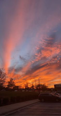 the sun is setting over an empty parking lot