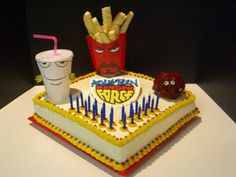 a birthday cake with fries, ketchup, and a drink on the table