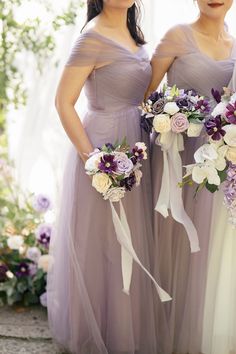 two bridesmaids in purple dresses holding bouquets