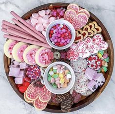 a platter filled with lots of different types of heart shaped cookies and candies