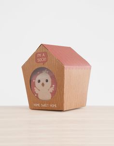 a small wooden house shaped like a birdhouse with a pink roof and the words home sweet home printed on it