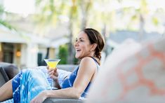 a woman sitting in a chair holding a drink