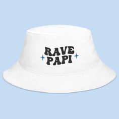 Introducing our "Rave Papi" Bucket Hat – a stylish addition to your rave and festival wardrobe. This hat is perfect for those who love to immerse themselves in the colorful and high-energy atmosphere of music festivals and raves. Embrace the festival vibes with this eye-catching bucket hat. The "Rave Papi" design signifies your passion for the rave culture and the EDM scene, making it an ideal choice for expressing your love for electronic music and the electrifying festival experience. Whether Retro Adjustable Sun Hat For Festivals, Adjustable Retro Sun Hat For Festivals, Adjustable Rave Cap, Trendy White Sun Hat For Festival, Retro Adjustable Hats For Festivals, Trendy Adjustable Bucket Hat For Music Festival, Summer Rave Festival Hats, Trendy Adjustable Costume Hats And Headpieces For Festival, Fun Festival Bucket Hat With Curved Brim