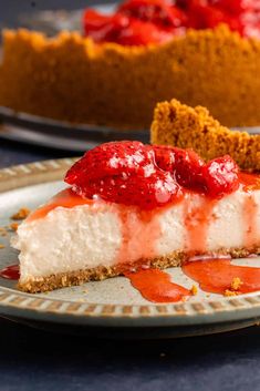 a slice of cheesecake with strawberries on top and graham crackers in the background