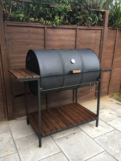 an outdoor bbq grill is shown in front of a fence