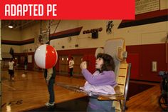 a woman sitting in a chair on top of a hard wood floor next to a red and white ball