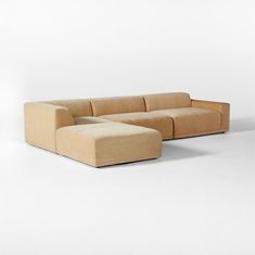 a beige couch sitting on top of a white floor