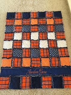 an orange and blue patchwork quilt with the name jordan genee written on it