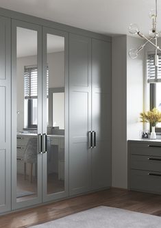 a bedroom with mirrored closet doors and drawers in it's center, along with a rug on the floor