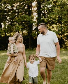 a family walking through the grass holding hands