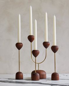 a set of five candles sitting on top of a wooden stand next to each other