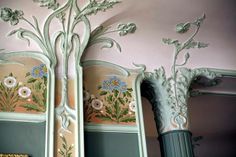 an ornately painted wall and mirror in a room