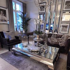 a living room filled with furniture and a chandelier hanging over the top of it