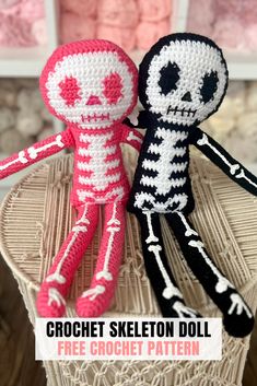 two crocheted skeleton dolls sitting next to each other on top of a table