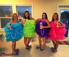 four women dressed in brightly colored dresses holding cell phones