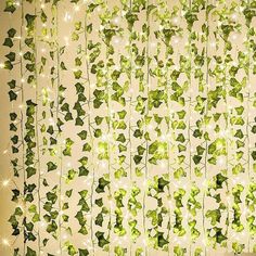 green ivy vines are hanging from the ceiling with lights on them and some white stars in the background