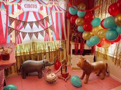 a circus themed birthday party with balloons and animals on the floor, including an elephant cake