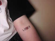 a close up of a person's arm with the word lover tattooed on it