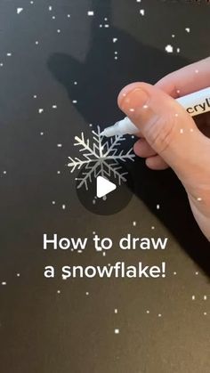 someone is holding a snowflake in their left hand and writing on it with the word how to draw a snowflake