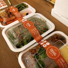 three plastic containers filled with food on top of a wooden table