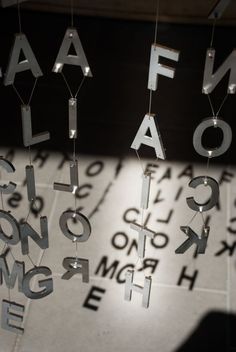 the letters are hanging from strings on the wall