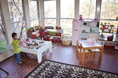 a little boy standing in front of a play table with toys on top of it