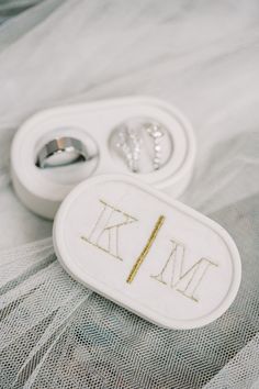 two wedding rings sitting on top of a bed