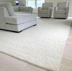 a living room filled with furniture and white carpet